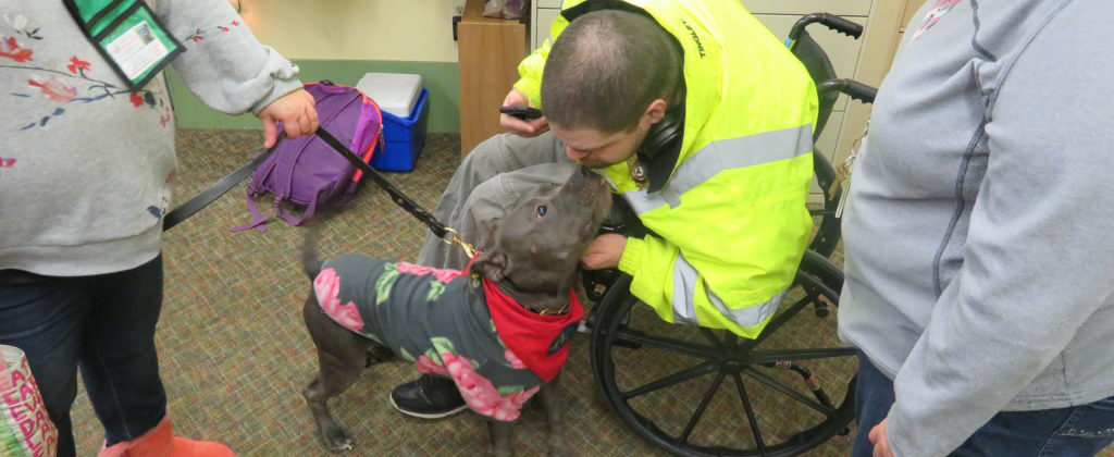 Diamond visiting with a man in a wheelchair